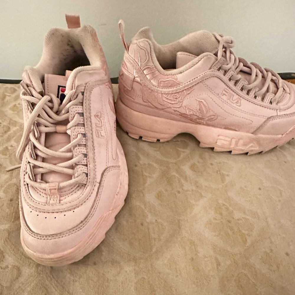 Pink Filas with roses on the side.